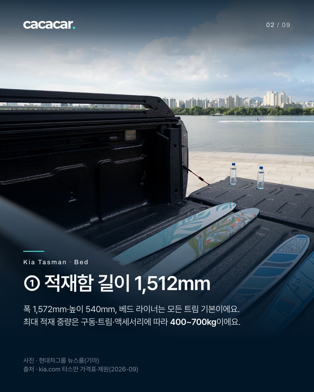 2장. 강변 쪽으로 테일게이트를 연 타스만 적재함 안쪽으로, 검은 베드 라이너 바닥에 보드 여러 개가 놓여 있고 테일게이트 위에 물병 두 개가 있다. 제목 '① 적재함 길이 1,512mm'.