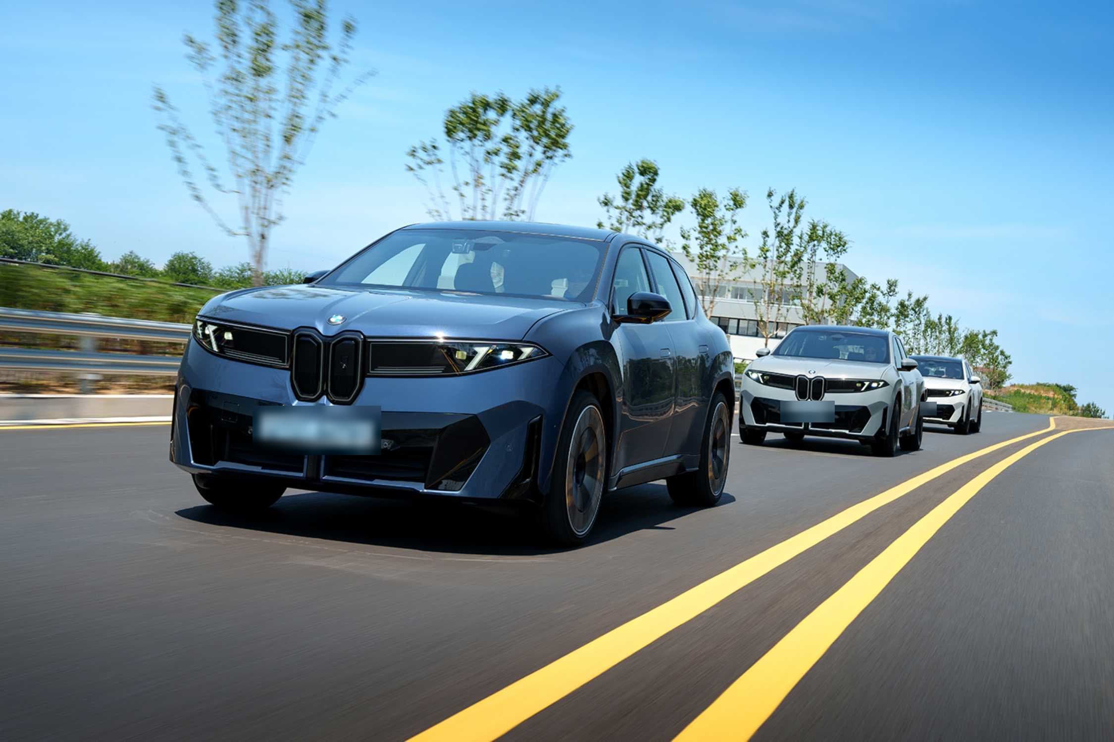 도로를 달리는 남색 BMW iX3 앞모습과 뒤따르는 흰색 iX3들 (번호판 가림)