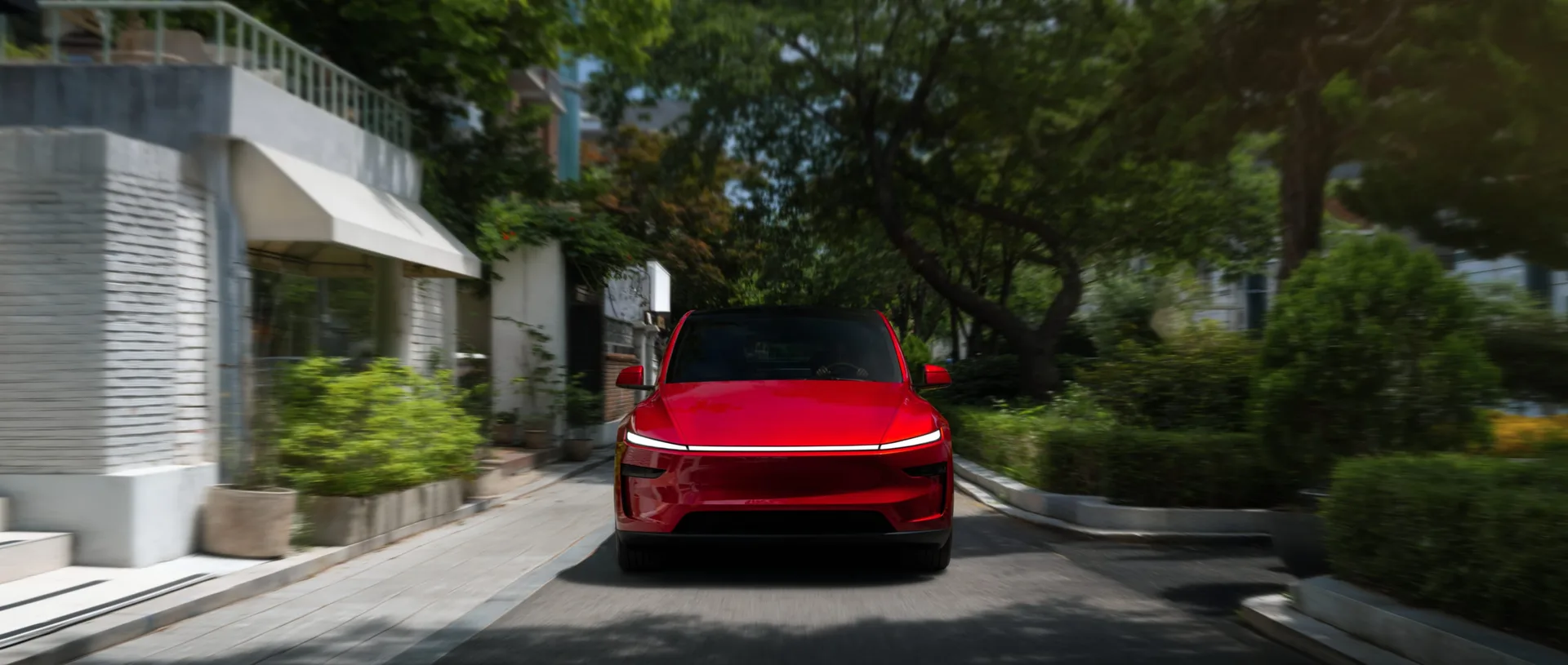 도심을 달리는 붉은색 Tesla Model Y